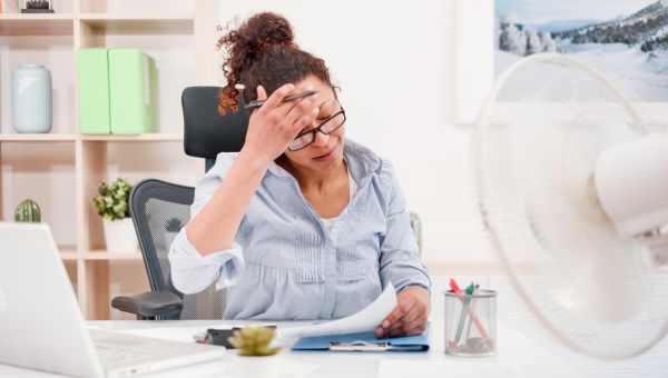 woman having a hot flash at her desk
