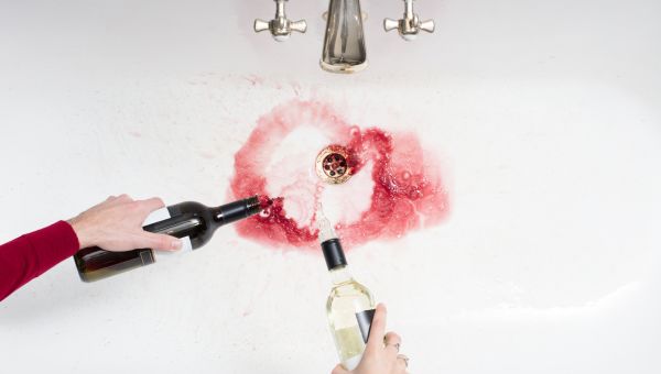 Pouring away wine in an act of giving up alcohol