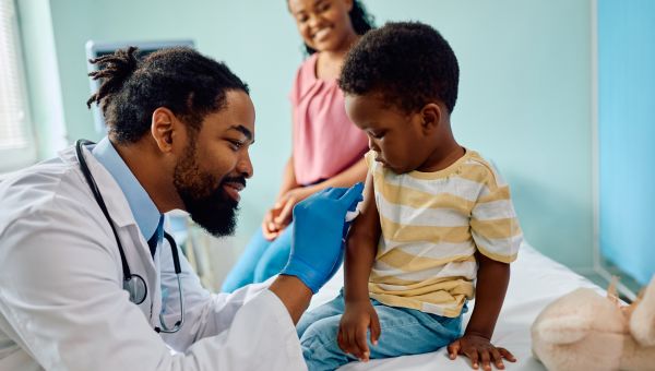 child getting vaccine shot from a doctor