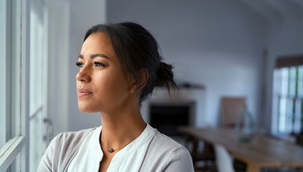 woman reflecting to self in the light of a window