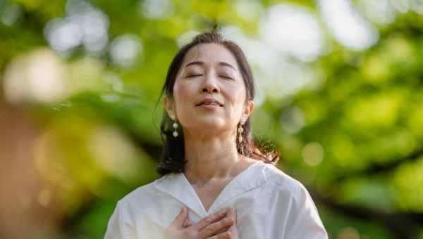 woman taking a moment to breathe in nature