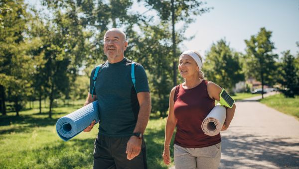 mature husband and wife with yoga mats