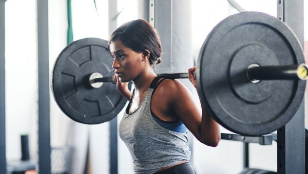 young woman lifting weights at gym