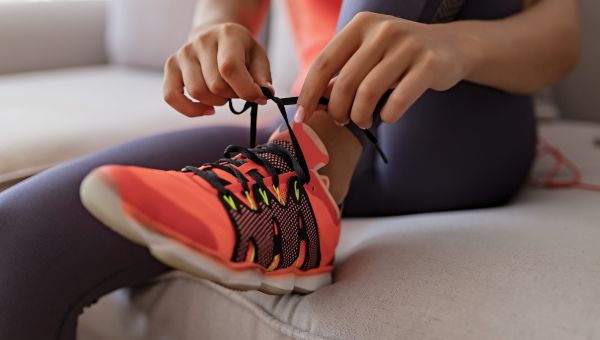 woman lacing up sneakers