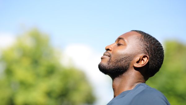 a young Black man takes a deep breath to calm himself down
