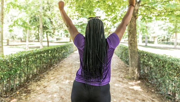Someone standing and raising arms to make victory sign