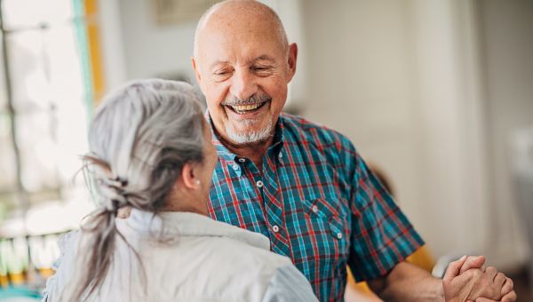 two older people dancing and smiling