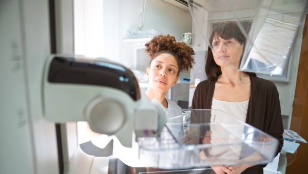 doctor and patient looking at mammography machine