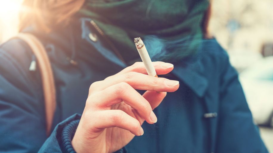 Woman smoking a cigarette outside.