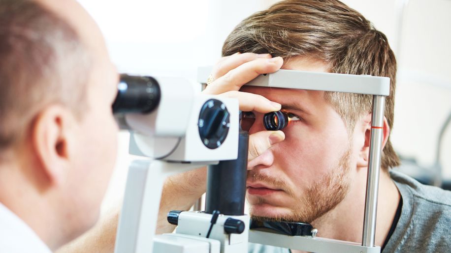Optometrist gives man an eye and vision test.