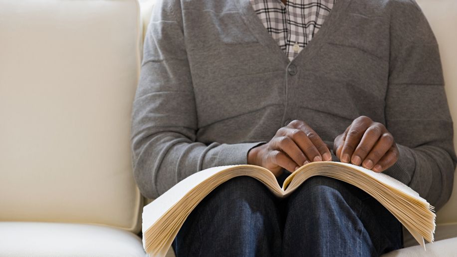 Woman reads a braille book.