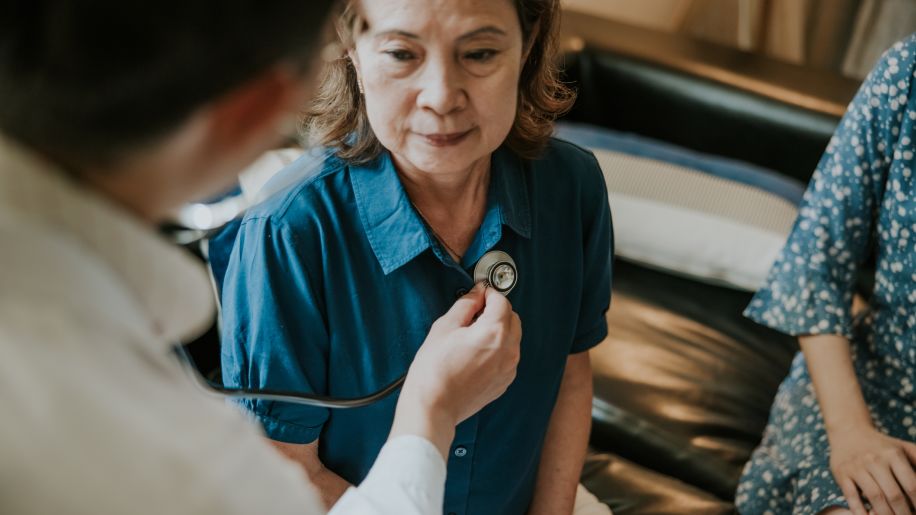 woman receiving an exam of lungs by doctor