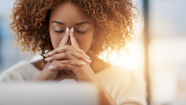 young woman with eyes closed in front of computer