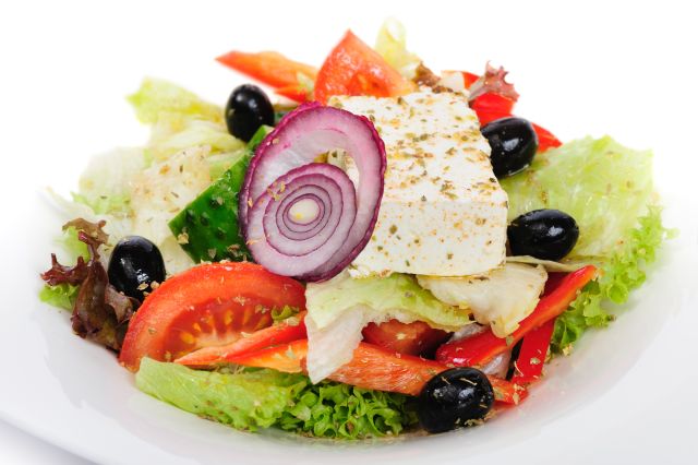 closeup of greek salad with large piece of feta