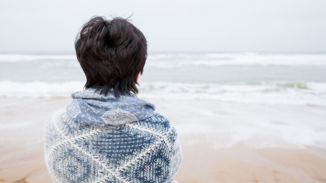 Happy mature attractive woman staring out to sea
