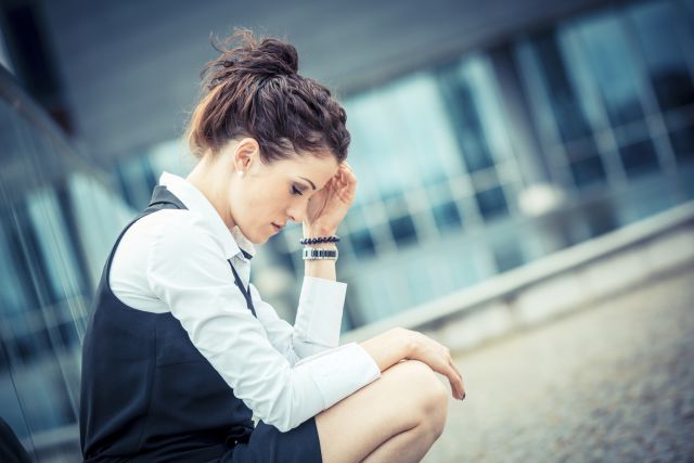 Tired or depressed business professional outside