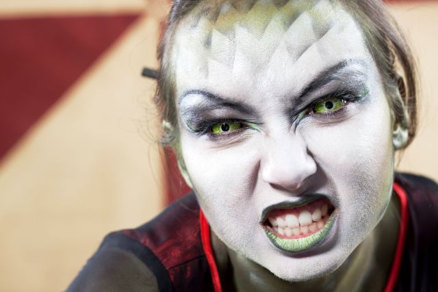Snake Woman baring her teeth at the camera.