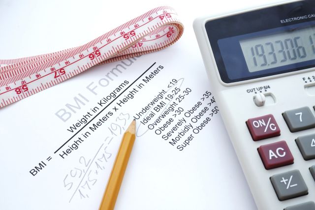 A measuring tape, calculator and formula for determining body mass index.  