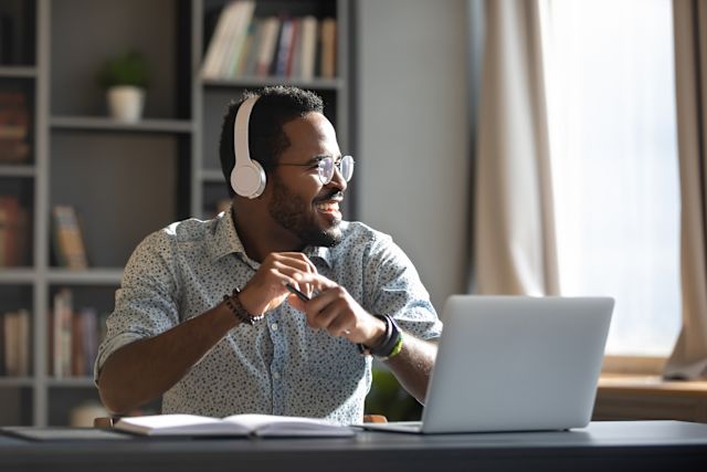 Man wearing headphones, holding long playing record