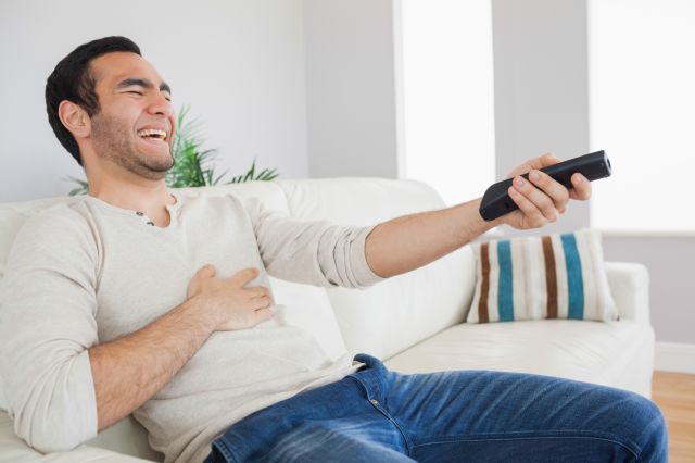 Someone bursting out laughing while watching tv