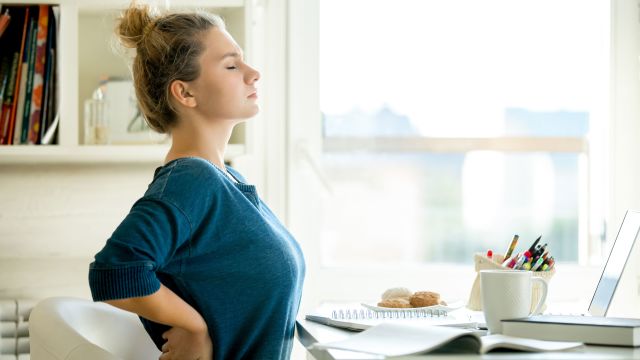 A woman passing kidney stones holds her back in pain. She wishes she knew how to prevent kidney stones.