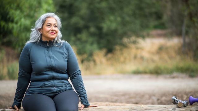 Woman sitting outdoors near workout equipment