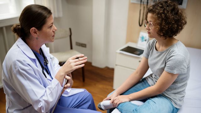 Doctor is checking up on young female patient