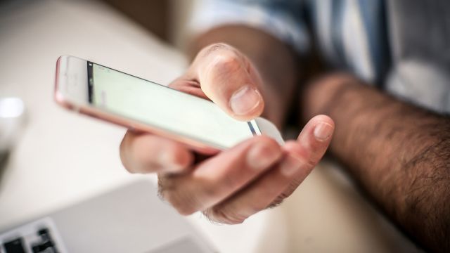 A man using his phone to look up resources for soft tissue sarcoma.