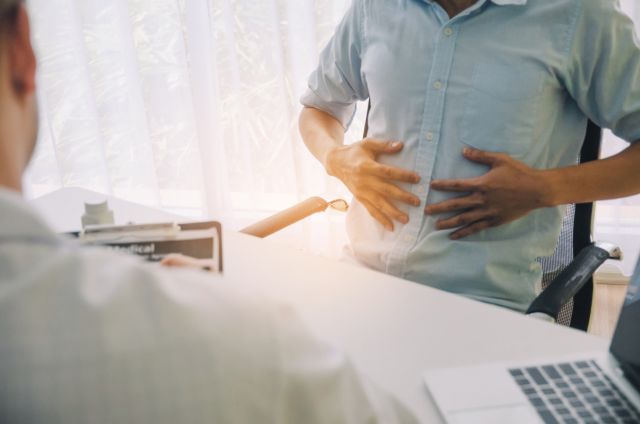 man talking to doctor about abdominal pain