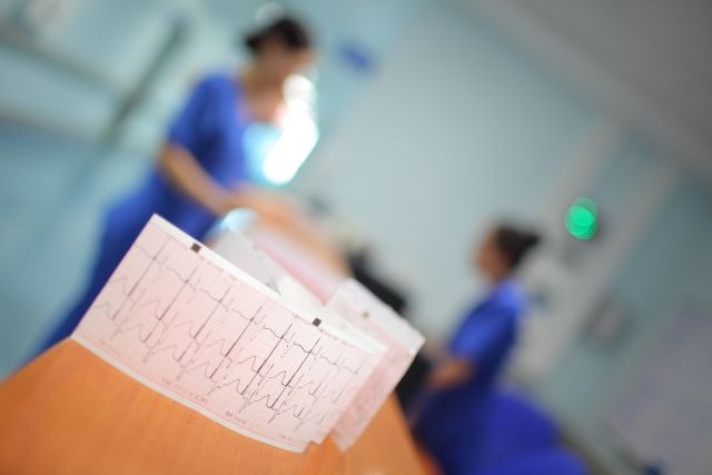 EKG tape with medical team and patient in background