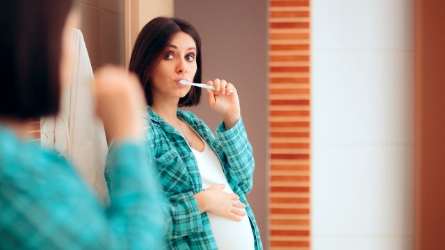 pregnant person brushing teeth