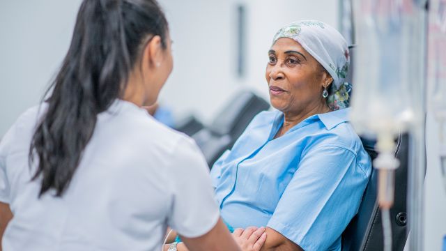 Woman with stage III lung cancer visiting with a nurse.