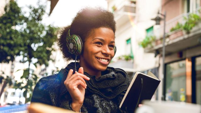 Young black woman wearing headphones outside