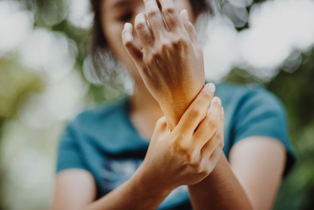 A woman experiences wrist pain from rheumatoid arthritis. Anemia is more prevalent among people who have RA.