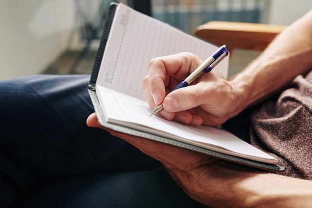 A man writes in a journal. Writing can help you process the emotional and mental burden of living with a diagnosis like CML.