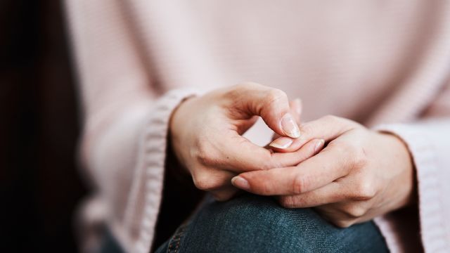 woman picking at her nails