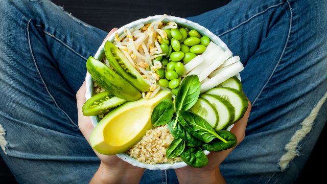 A bowl full of quinoa, cucumber, avocado, bean sprouts and edamame.