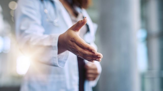 A doctor offering their hand to a patient.