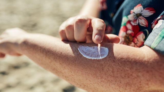 A man applying sunscreen to help prevent skin cancer.