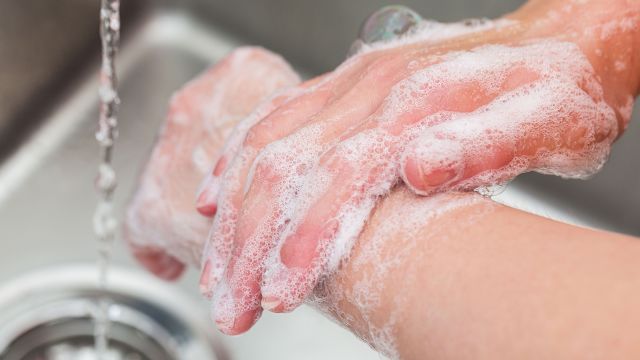 Woman washing her hands with soap and water
