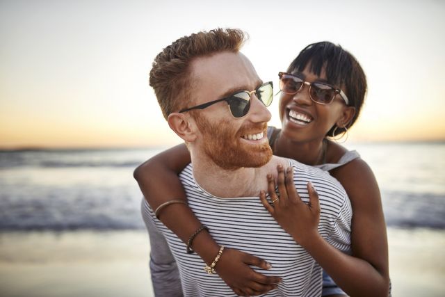 a happy couple hugs on the beach