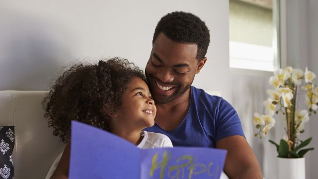 Father reads a handmade card given to him by his daughter.