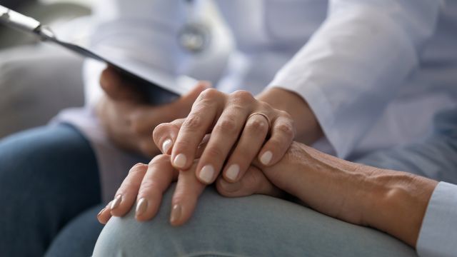 A doctor comforts a patient during a medical visit.