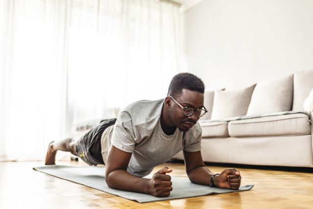 young man planking in a living room