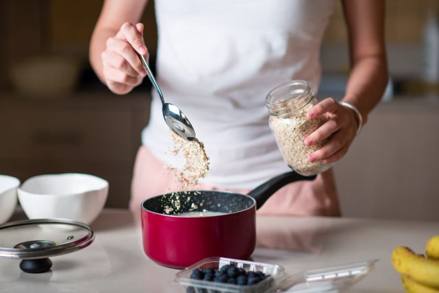 A person making blueberry oatmeal to help combat IBD