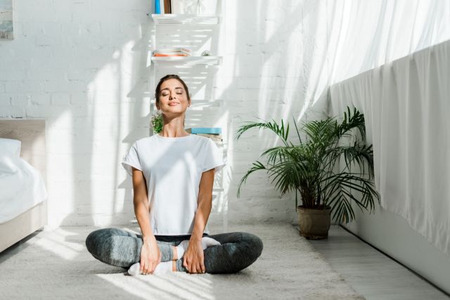 a young person meditates in a bright sunny room