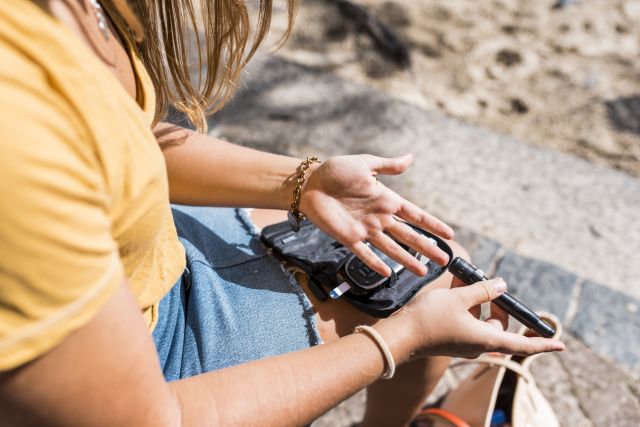 young adult checking blood sugar level