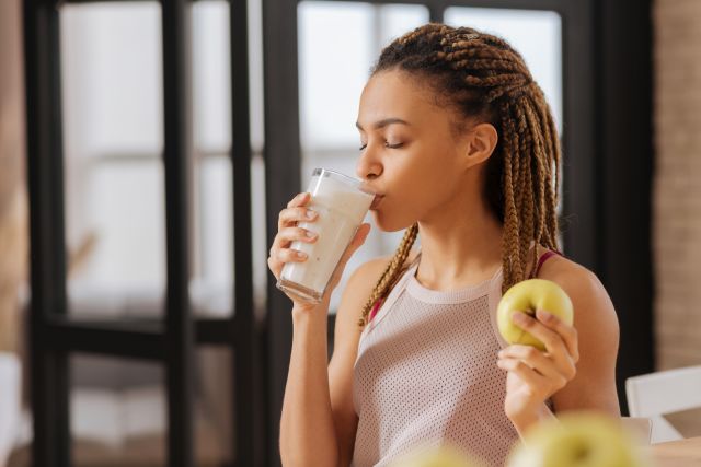 a young Black woman drinks milk after exercising