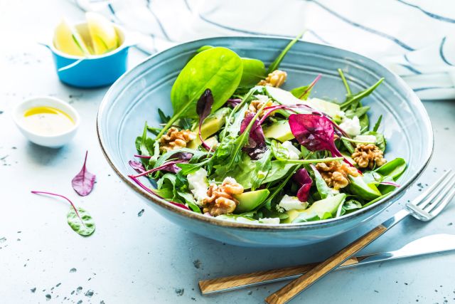 a vibrant salad with mixed greens, avocado, and walnuts 