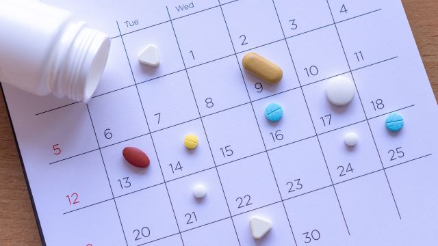 Pain-relieving medication spread out on a calendar. 